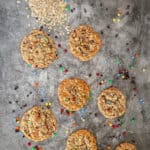 8 gluten free monster cookies scattered with m and m candies around them