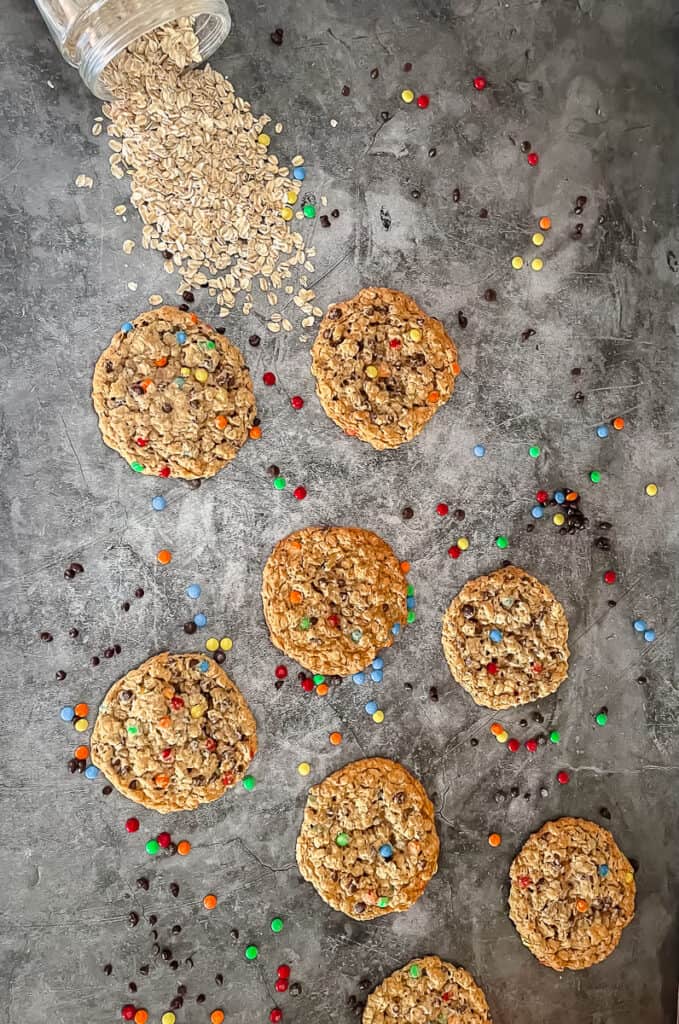 8 monster cookies scattered with m and m candies around them