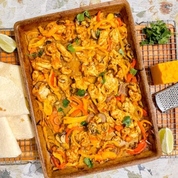 Chicken Fajitas on a sheet pan surrounded by their toppings