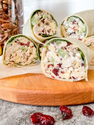 Cranberry Apple Pecan Chicken Wraps on a wooden cutting board