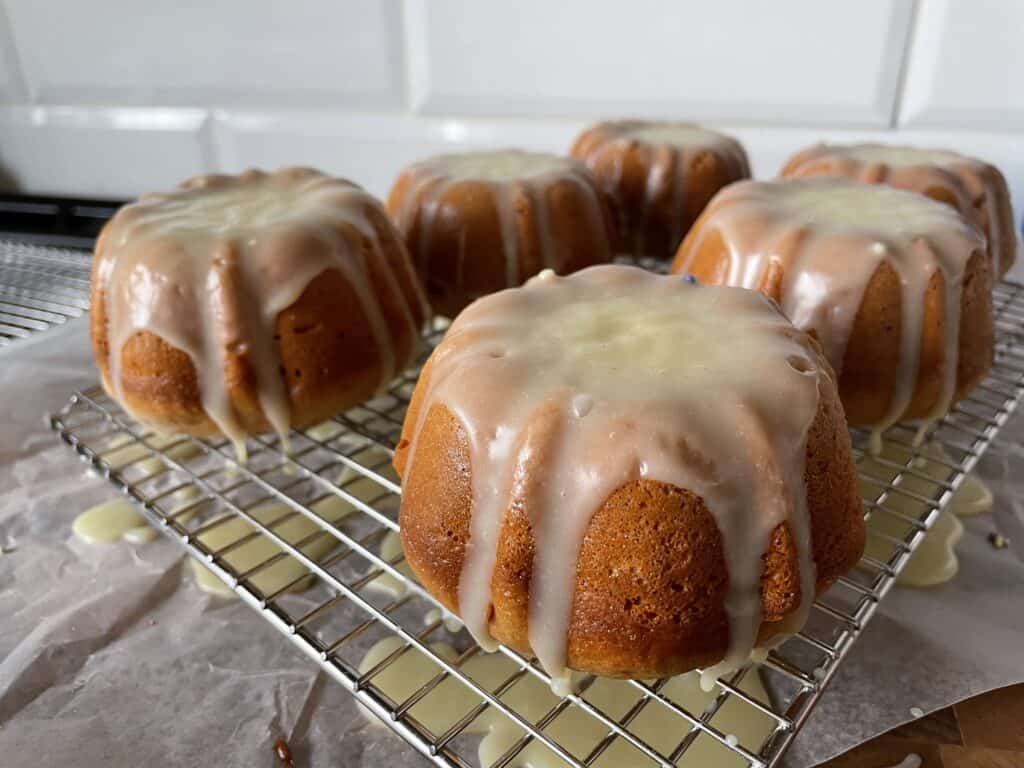 mini bundt cakes with a white chocolate ganache on a cooling rack