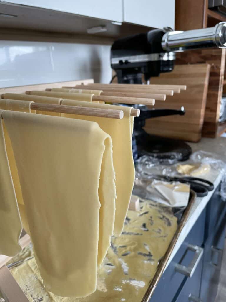 fresh pasta sheets on a wooden dowel