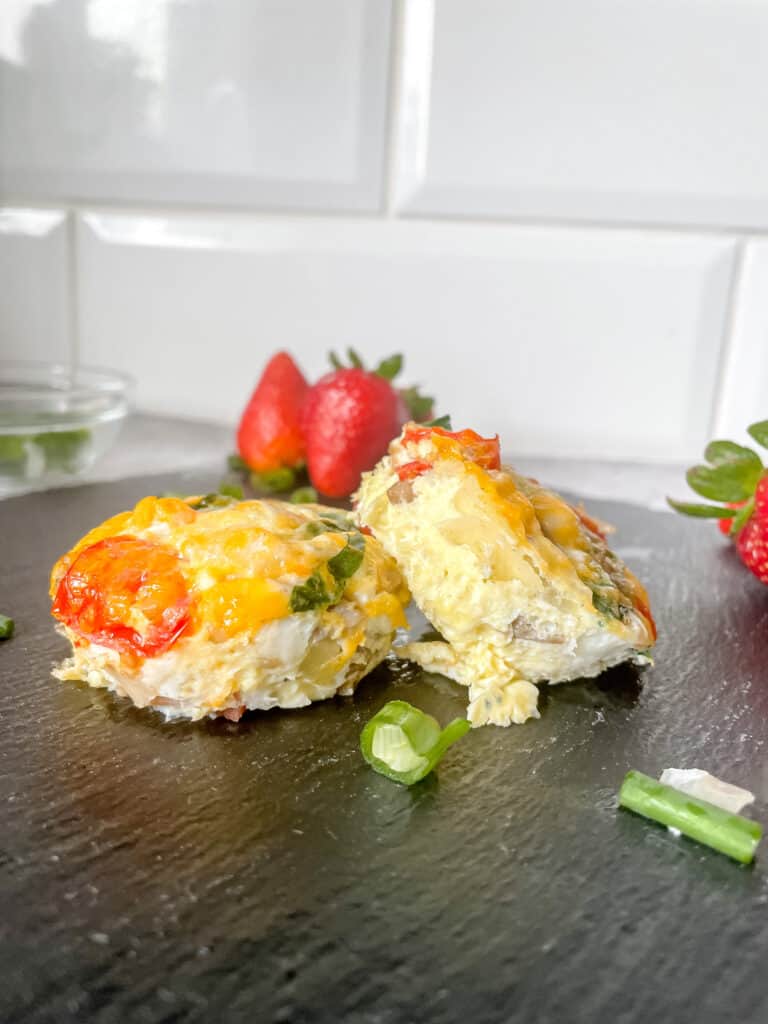 Frittata Muffins on a black slate plate with strawberries