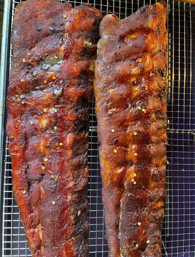 oven cooked ribs vs smoked pork ribs side by side on a wire rack