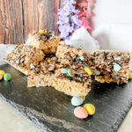 Mini Egg Rice Krispies on slate plate with flowers in the background