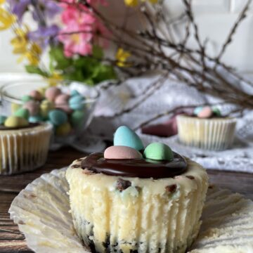 close up of mini egg mini cheesecakes with flowers in the background